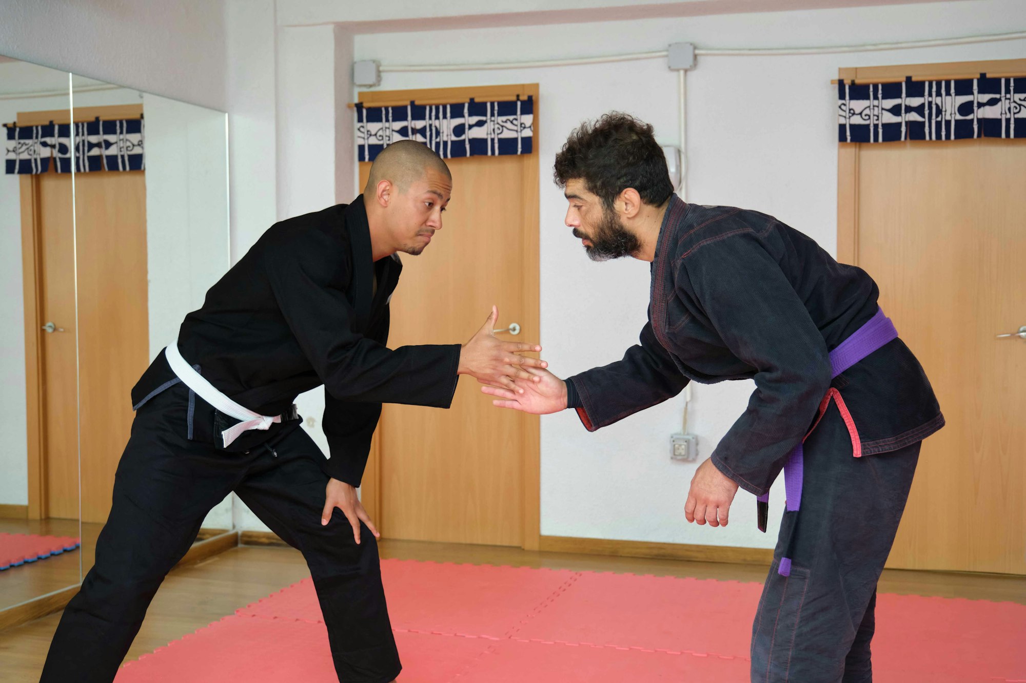 Two men greeting before Brazilian Jiu-Jitsu fight session at the Academy.