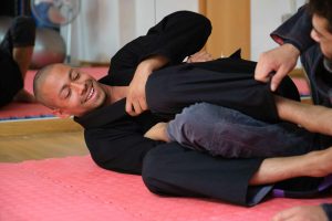 Two men practicing Brazilian Jiu-Jitsu sparring at the Academy.
